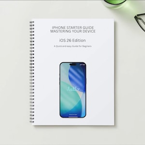 以下が含まれることがあります： 「iPhone Starter Guide Mastering Your Device iOS 26 Edition」と書かれた白いリング綴じノート。表紙には、青と緑の画面のスマートフォンが表示されています。「A Quick and easy Guide for Beginners」というテキストも表示されています。