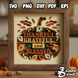 Può includere: Un'opera d'arte in carta a strati incorniciata, con un design a zucca e le parole "THANKFUL, GRATEFUL, and BLESSED." L'opera utilizza colori autunnali: arancione, verde e marrone, con accenti di foglie. Il testo "SVG PNG DXF PDF EPS" è presente.