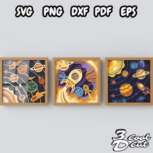 May include: Three framed space-themed paper cut art pieces. Each features a layered design with planets, rockets, and celestial elements in shades of orange, blue, and yellow. The top text reads "SVG PNG DXF PDF EPS" and the bottom text reads "3 Cool Cut".