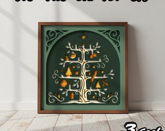 Könnte beinhalten: Gerahmtes, mehrschichtiges Papierkunstwerk mit einem stilisierten Baumdesign. Der Baum ist goldfarben auf einem dunkelgrünen Hintergrund, mit dekorativen Elementen wie Vögeln und Kerzen. Der Rahmen ist dunkelbraun. Oben stehen die Worte "SVG PNG DXF PDF EPS".
