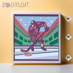 May include: A framed 3D paper art piece showing a hockey player in a maroon uniform with the number 17, about to hit a puck. The background features a stadium with green and red seating, snowflakes, and the text "3D COOLCUT".