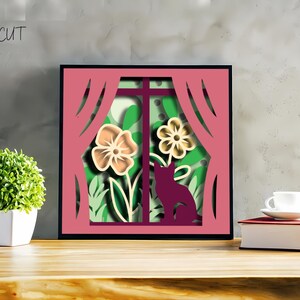 Layered 3D papercut shadow box showing a cute cat gazing through a spring window surrounded by flowers, leaves, and seasonal nature elements. Designed for Cricut, Silhouette, and other cutting machines, this DIY papercraft design is ideal for cat lovers, spring decorations, or handmade seasonal gifts. Beautifully detailed and easy to assemble, perfect for adding a warm spring vibe to any room.