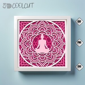 Pode incluir: Uma obra de arte em papel em camadas com uma figura meditando dentro de um design de mandala. A obra de arte é predominantemente rosa e branca, emoldurada em uma moldura branca. O texto "3D COOLCUT" é visível. Inclui formatos de arquivo DXF, PNG e SVG.