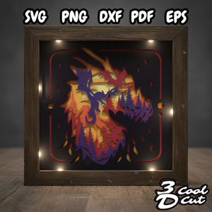 May include: A framed, layered paper art piece featuring a dragon design in shades of orange, red, and purple, set against a black background. The frame is made of wood and has small lights around the inner edge. The top of the frame has the text "SVG PNG DXF PDF EPS".