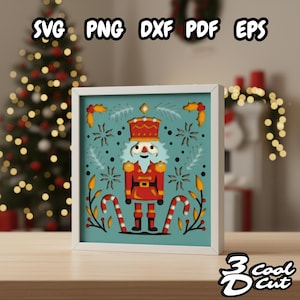 Puede incluir: Una obra de arte navideña enmarcada con un soldado cascanueces rojo y dorado con barba blanca, sobre un fondo turquesa con copos de nieve y bastones de caramelo. El marco es blanco y la obra está etiquetada con "SVG PNG DXF PDF EPS" y "3 Cool Cut".