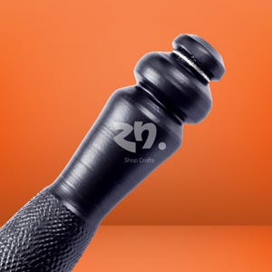 May include: A black tool handle featuring a smooth, contoured grip section that transitions into a rounded, bulbous top. The lower portion of the handle displays a textured, cross-hatched pattern. The logo zn. Shop Crafts is printed in white.
