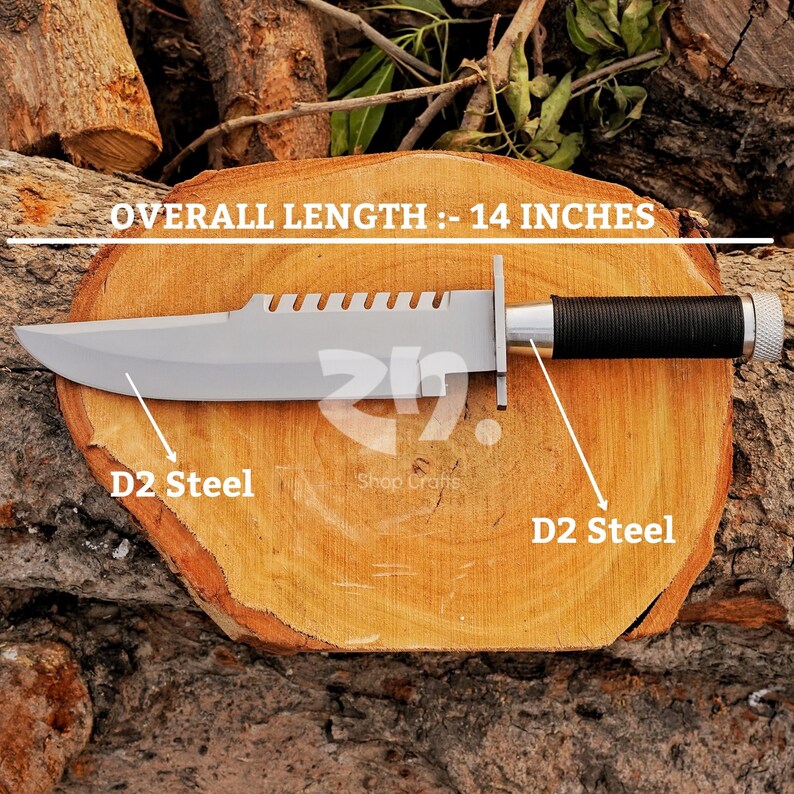 May include: A silver D2 steel knife with a black handle, overall length 14 inches. The knife is displayed on a wooden surface with the text "OVERALL LENGTH :- 14 INCHES" and "D2 Steel".
