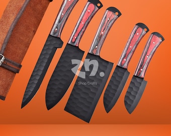 May include: A set of five black kitchen knives with red and gray wooden handles. The blades have a textured surface. A brown leather knife roll is visible on the left side. The text "ZN. Shop Crafts" is in the center.