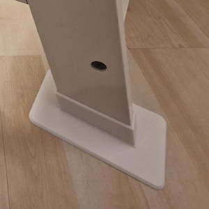 Könnte beinhalten: Weißes Möbelbein aus Metall mit einem runden Loch und einer weißen Kunststoffbasis.