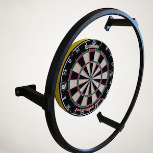 K&ouml;nnte beinhalten: Ein schwarzer Dartscheibenrahmen aus Metall mit einer Winmau Masters Pro Dartscheibe. Die Dartscheibe hat einen schwarzen Hintergrund mit roten, gr&uuml;nen und wei&szlig;en Details. Der Rahmen ist kreisf&ouml;rmig und an der Wand montiert.