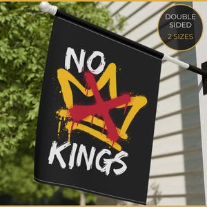 May include: A black rectangular garden flag featuring the white text NO KINGS. A yellow spray-painted crown graphic is centred on the flag, overlaid with a large red X. The design includes paint drip effects and a circular badge stating DOUBLE SIDED 2 SIZES.