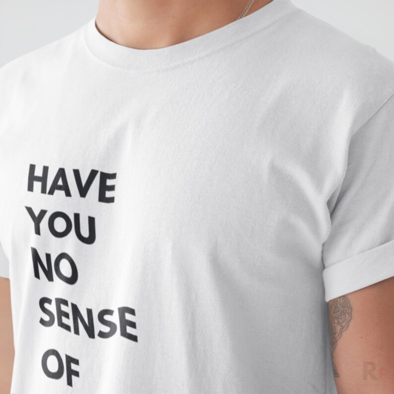 A white t-shirt with the text "HAVE YOU NO SENSE OF" printed on it.