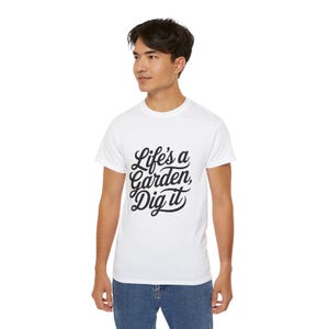 May include: White t-shirt with black text that reads "Life's a Garden, Dig it" in a stylized font.