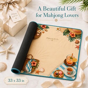Puede incluir: Un tapete de mahjong enrollado con un dise&ntilde;o de tem&aacute;tica playera, con una cesta, un sombrero y flores tropicales. El tapete mide 84 x 84 cm y tiene el texto "Mahjong by the Sea" y "A Beautiful Gift for Mahjong Lovers".