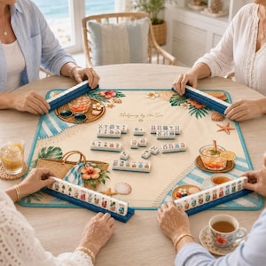 Puede incluir: Un juego de Mahjong sobre un tapete con tem&aacute;tica de playa con el texto "Mahjong by the Sea". El tapete presenta un borde a rayas azules y blancas, detalles florales y una bolsa de paja. El juego est&aacute; configurado con fichas y estantes azules.