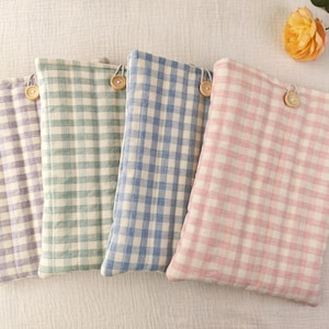 May include: Four rectangular fabric pouches featuring a gingham check pattern in lavender, sage green, blue, and pink. Each pouch is quilted with a soft texture and includes a single wooden button closure attached with a small loop at the top centre.