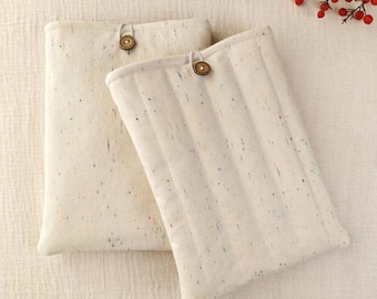 May include: Two rectangular off-white fabric pouches featuring a speckled pattern of tiny multicolored flecks. Each pouch is secured with a single small brown wooden button and a loop closure. The fabric has a quilted texture with vertical stitching.