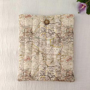 May include: A rectangular quilted fabric sleeve featuring an antique map print in shades of beige, brown, and black. The sleeve is secured at the top centre with a single round brown wooden button and a small fabric loop closure.