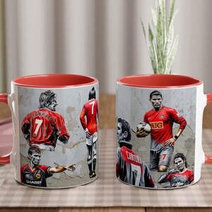 May include: Two red and white ceramic mugs with images of famous soccer players. The mugs feature images of David Beckham, Cristiano Ronaldo, Wayne Rooney, and Ryan Giggs. The mugs have red handles and red rims.
