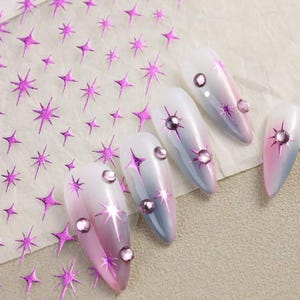 May include: Pink and white ombre nail polish with pink glitter star nail stickers and clear rhinestones.