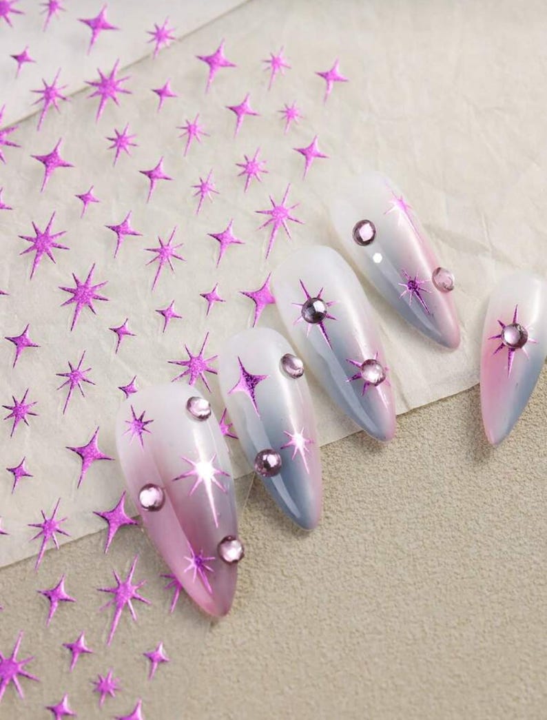 May include: Pink and white ombre nail polish with pink glitter star nail stickers and clear rhinestones.