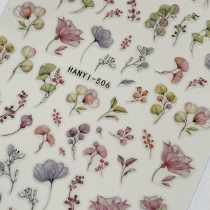 Op de afbeelding: Een vel bloemenstickers met bloemen en bladeren in aquarel-stijl in tinten roze, paars, groen en rood. De tekst "HANYI-506" is op het vel gedrukt.