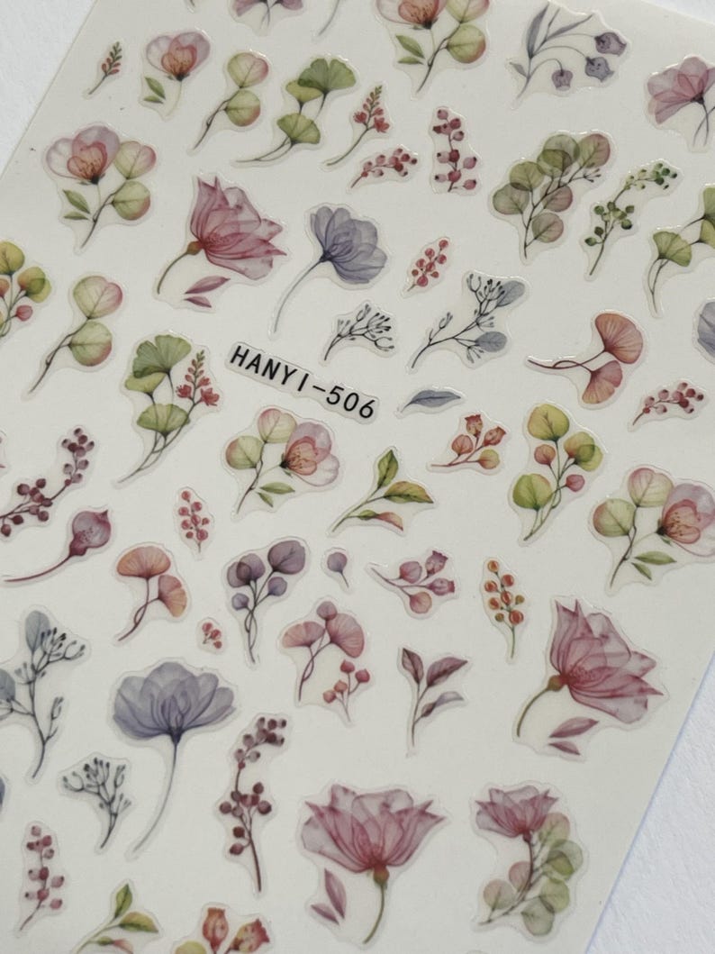 Op de afbeelding: Een vel bloemenstickers met bloemen en bladeren in aquarel-stijl in tinten roze, paars, groen en rood. De tekst "HANYI-506" is op het vel gedrukt.