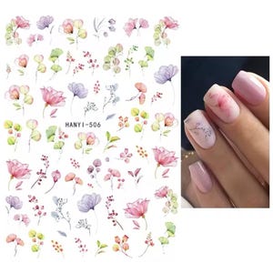 Op de afbeelding: Vel met nail art stickers met aquarel bloemmotieven in roze, paars en groen. De vel bevat verschillende bloem- en blad illustraties, met de tekst "HANYI-506". Een close-up toont nagels met vergelijkbare bloemmotieven.