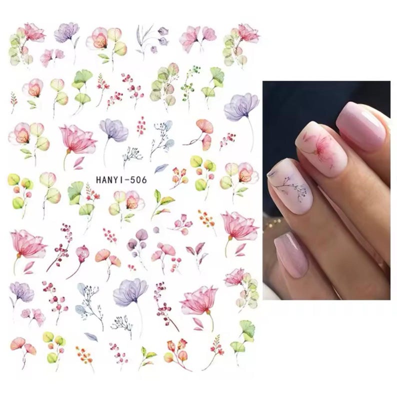 Op de afbeelding: Vel met nail art stickers met aquarel bloemmotieven in roze, paars en groen. De vel bevat verschillende bloem- en blad illustraties, met de tekst "HANYI-506". Een close-up toont nagels met vergelijkbare bloemmotieven.