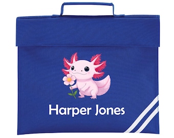 May include: A royal blue school satchel with a top handle and flap closure. The front features a pink axolotl holding a flower, with the name "Harper Jones" in white. White stripes accent the lower right corner.