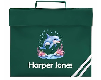 May include: A dark green school satchel with a white handle and a flap closure. The front features a blue dolphin illustration with coral and the name "Harper Jones" in white. Two white stripes run down the right side.