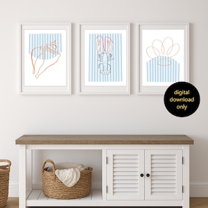 May include: Three framed art prints with white frames. Each print features a line drawing on a white background with blue vertical stripes. The drawings include a seashell, a lobster, and a flower. The text "digital download only" is in a black circle.