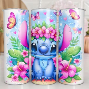 May include: Three white insulated tumblers featuring a blue cartoon character with large ears, wearing a flower crown. The design includes pink hibiscus flowers, butterflies, and hearts on a light blue background. The tumblers are decorated with a tropical theme.