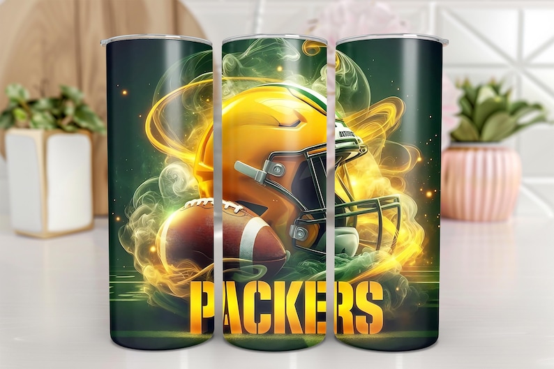 Pode incluir: Tr&ecirc;s copos verdes e dourados com um capacete de futebol e bolas de futebol em um design esfuma&ccedil;ado. Os copos t&ecirc;m a palavra "PACKERS" impressa.