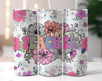 Op de afbeelding: Een bloemenbeker met het woord "TEACHER" in kleurrijke letters in retrostijl. Het ontwerp toont roze, paarse, oranje en witte bloemen op een lichte achtergrond. Er zit een rietje in de bovenkant.
