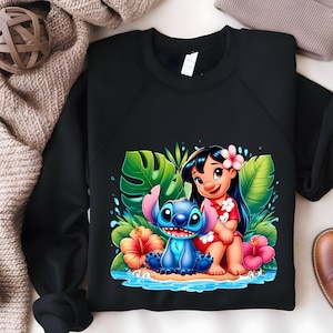 Pu&ograve; includere: Felpa nera con una grafica colorata di Lilo e Stitch. Il design mostra Lilo con un vestito rosso con un fiore tra i capelli e Stitch su una spiaggia con fiori e foglie tropicali. Un design divertente per i fan del film Disney.