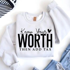May include: White sweatshirt with black text that reads "Know Your Worth Then Add Tax" with a small heart symbol after "Your".