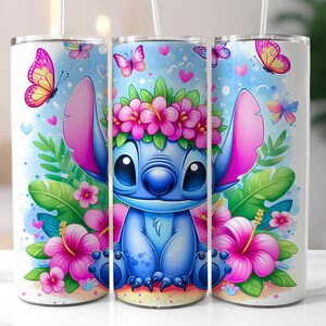May include: Three white insulated tumblers with a colorful cartoon design featuring a blue alien character wearing a flower crown, surrounded by pink flowers, butterflies, and green leaves. Each tumbler has a white straw.