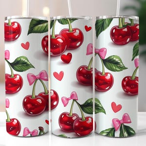 Puede incluir: Un vaso blanco con un diseño de cerezas rojas y lazos rosas. Las cerezas están dispersas por el vaso y algunas tienen hojas verdes.