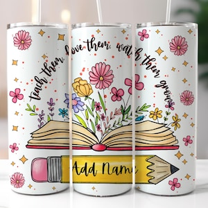 May include: White tumbler featuring a colourful floral design and an open book with a pencil underneath. The text on the tumbler reads "Teach them, love them, watch them grow".