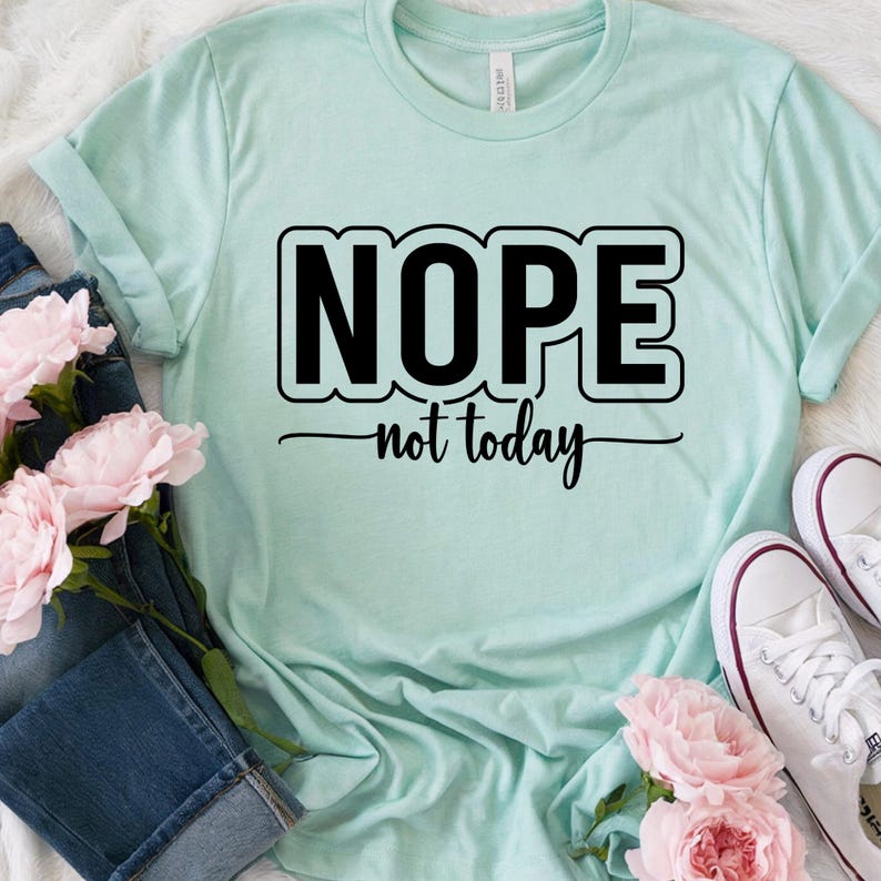 Op de afbeelding: Een lichtblauw T-shirt met zwarte tekst die "NOPE not today" zegt.