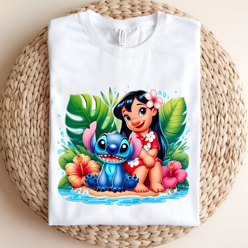 Pu&ograve; includere: T-shirt bianca con una grafica colorata di una ragazza dei cartoni animati e una creatura blu aliena, circondate da fiori e fogliame tropicali. Il design &egrave; ambientato su uno sfondo d'acqua azzurra.