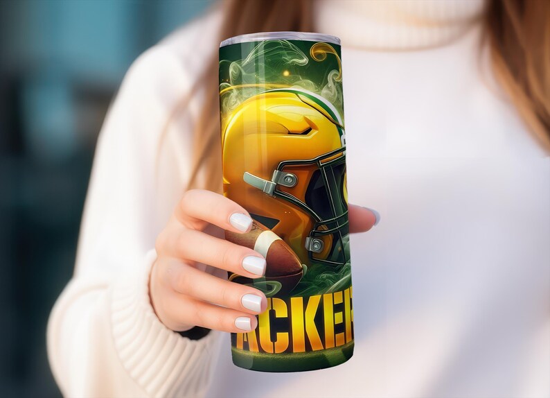 Pode incluir: Um copo verde e amarelo com um capacete de futebol e a palavra "Packers" nele.