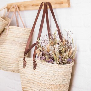 Long Leather Handle Straw Basket Bag, Beach Basket, filled with dried flowers hanging on a hook. French Style Market Basket, Straw Bag, French Market, Basket, grocery market bag