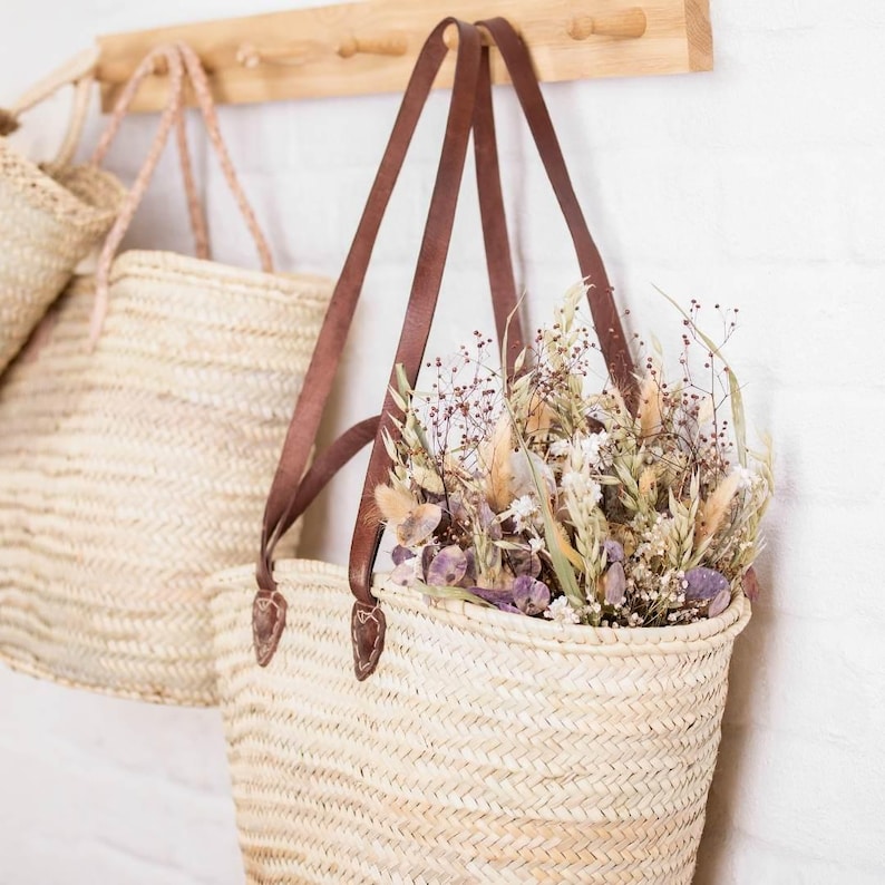 Long Leather Handle Straw Basket Bag, Beach Basket, filled with dried flowers hanging on a hook. French Style Market Basket, Straw Bag, French Market, Basket, grocery market bag