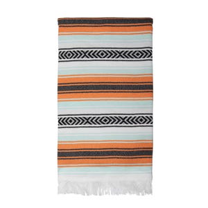 Peut inclure: Une couverture rayée avec une bordure en franges. La couverture présente des rayures alternées orange, blanches et bleu clair. Les rayures sont rehaussées de motifs géométriques noirs.