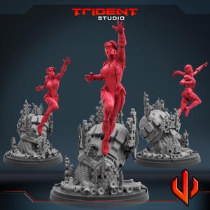 May include: Three red action figures of a woman in a futuristic suit, in dynamic poses. Each figure is mounted on a detailed grey base with mechanical and geometric elements. The Trident Studio logo is visible at the top.