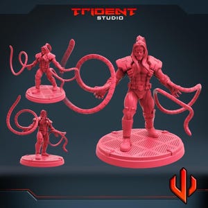 May include: Three red action figure models of a muscular man with long hair and a detailed suit. The central figure is the largest, with two long, curved appendages. The other two figures are smaller versions. The Trident Studio logo is visible.