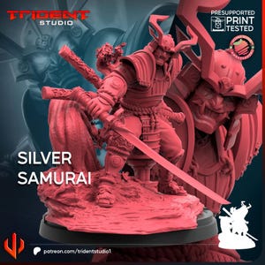 May include: A red monochromatic miniature figurine of a samurai warrior in traditional armour, holding a long katana sword. The figure stands on a textured base with a large helmeted head in the background. Text includes TRIDENT STUDIO and SILVER SAMURAI.