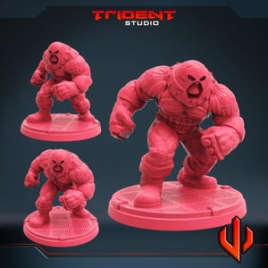 May include: Pink 3D-printed figurines of a muscular character in a helmet, posed in a fighting stance. The figures are on round, textured bases. The Trident Studio logo is visible in the top left corner.